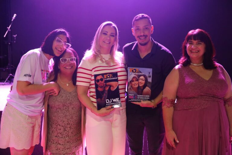Paula e DJ Wil segurando suas edições da Revista TOK durante o Desfile Projeto Mari’s em Botafogo