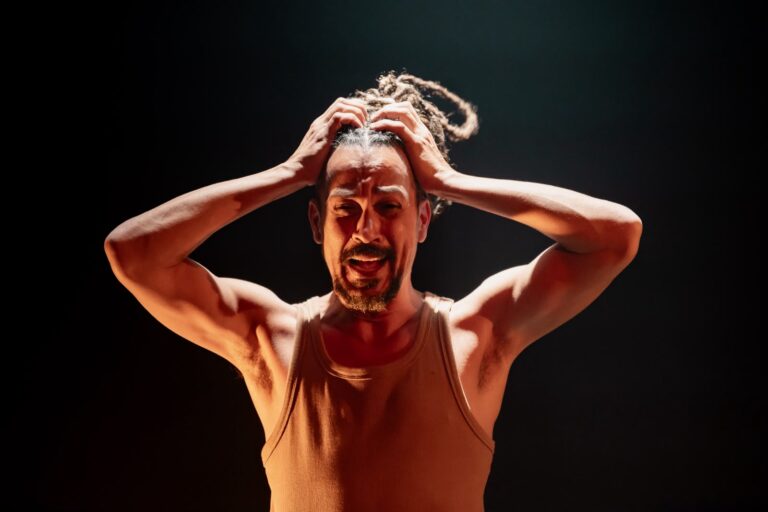 Gilberto Silva em cena na peça À beira da piscina um homem sentado no Teatro Ziembinski